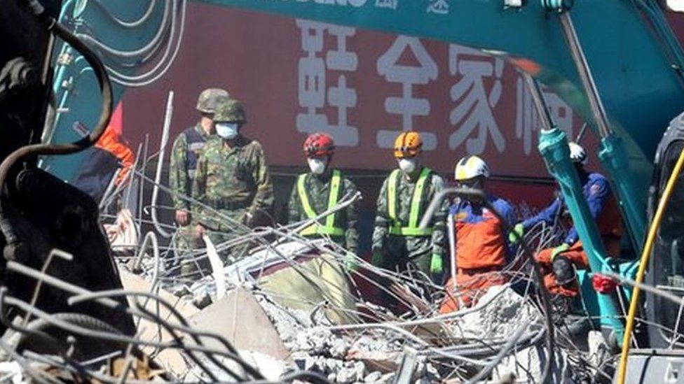 Heavy machines clear up the remains of a collapsed 17-storey buiding in Tainan City, south Taiwan, 13 February 2016.
