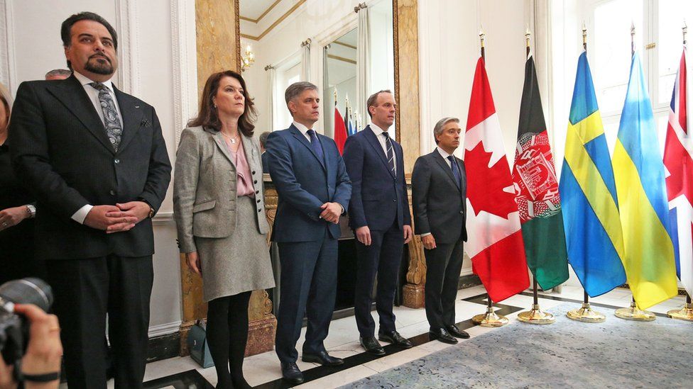 (Left to right) Ministers from Afghanistan, Sweden, Ukraine, Britain and Canada stand in a row as they reflect on the tragedy