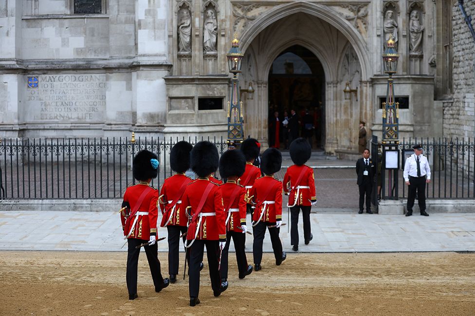Soldiers in ceremonial uniform walk into Westminster Abbey on the day of the state funeral and burial of Queen Elizabeth II at Westminster Abbey on 19 September 2022 in London