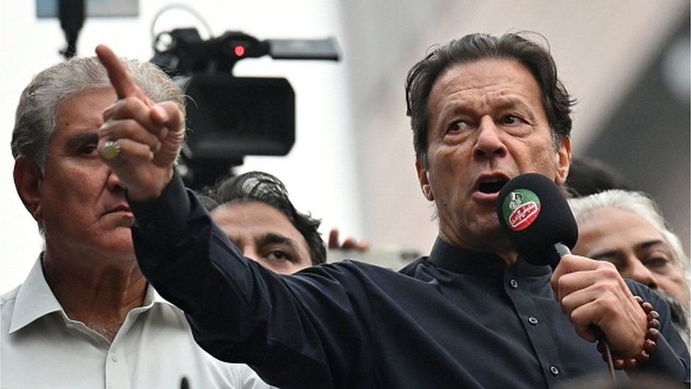 Pakistan's former prime minister Imran Khan (R) addresses his supporters