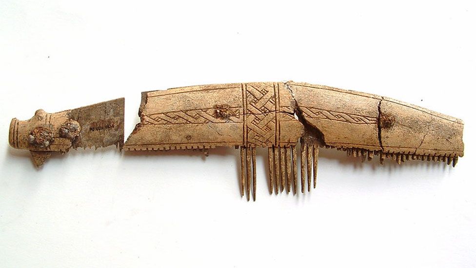 Carved Viking comb etched with design and missing most of its teeth