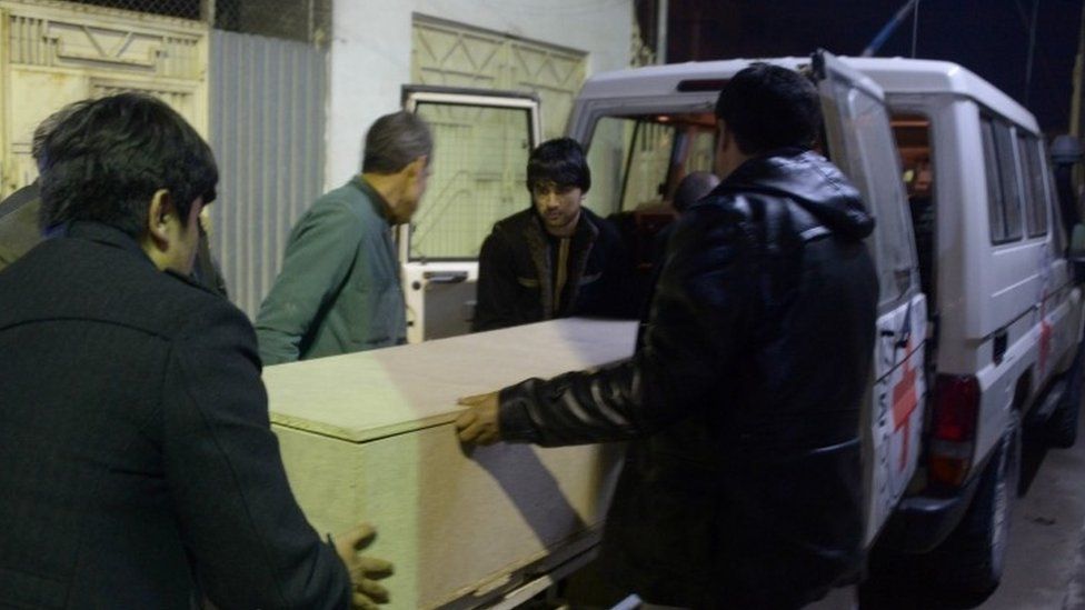 Afghan men unload a coffin of an International Committee of the Red Cross (ICRC) employee, who was killed by gunmen in Jwzjan province, at a hospital in Mazar-i-Sharif (08 February 2017)