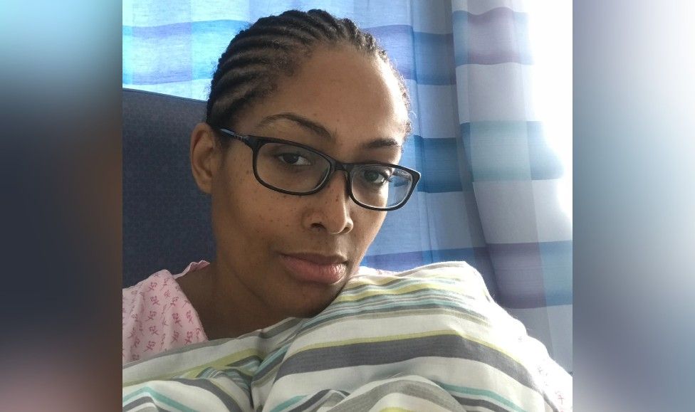 Dee Moore under a blanket in a hospital ward