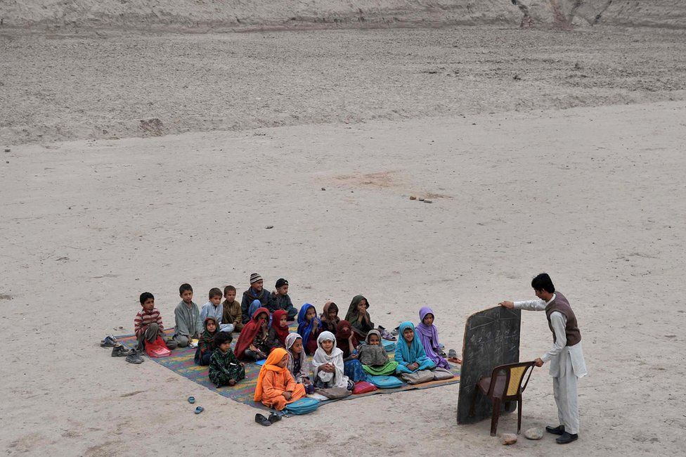 Афганские школьники берут уроки в открытом классе в лагере беженцев на окраине Джелалабада, провинция Нангархар, 1 декабря 2013 года.