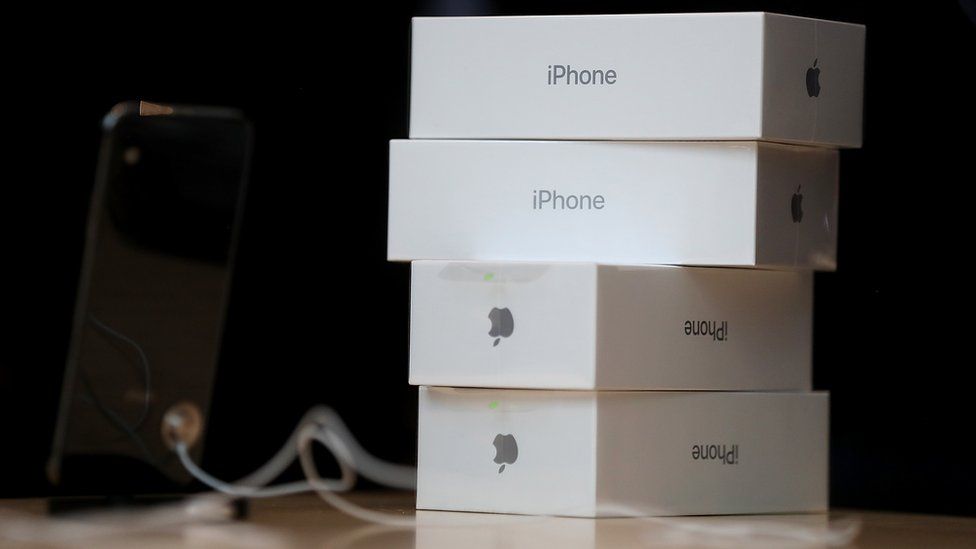 Boxes of the new iPhone X are stacked on top of one another next to a display item in an Apple Store.