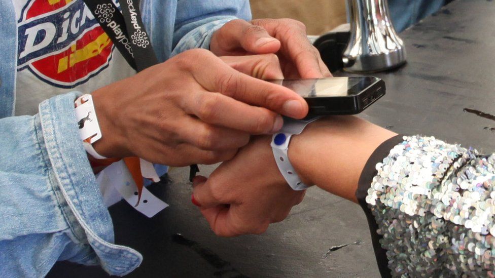 Festival attendee uses a wristband to pay