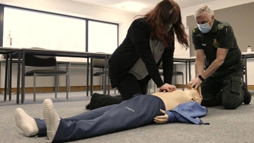 A woman being taught CPR on a dummy