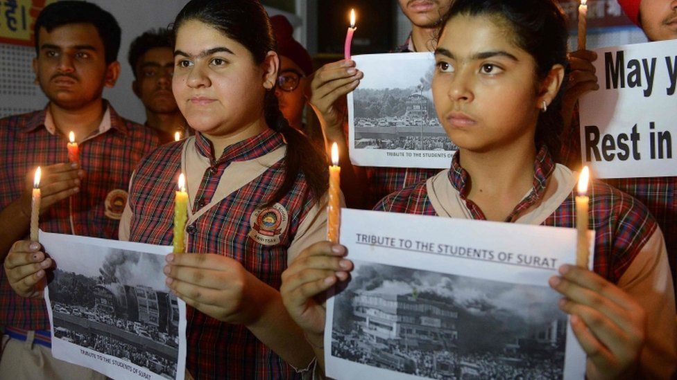 Indian students hold candles as they pay tribute to the students died in a fire in a building in India housing a college in Surat, at a school in Amritsar on May 25, 2019