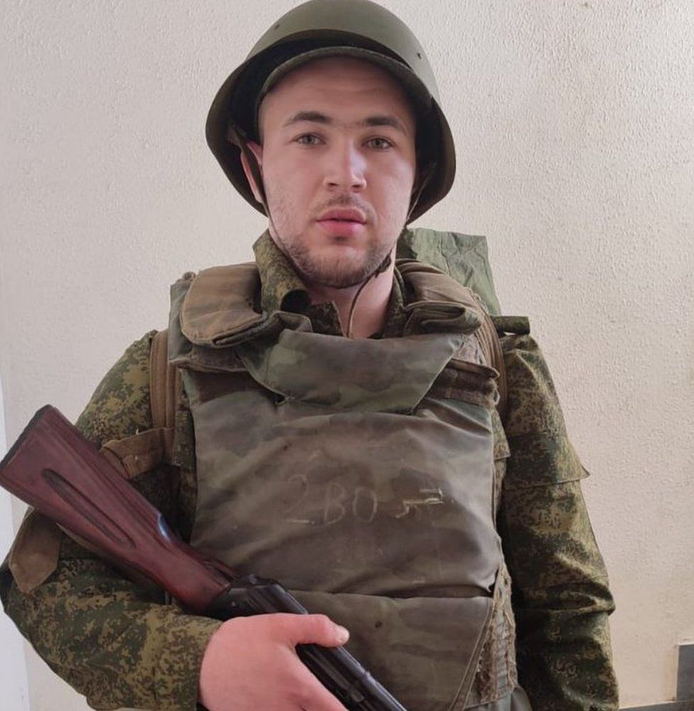 Photo of Yevgeny Chubarin in military clothes holding a rifle