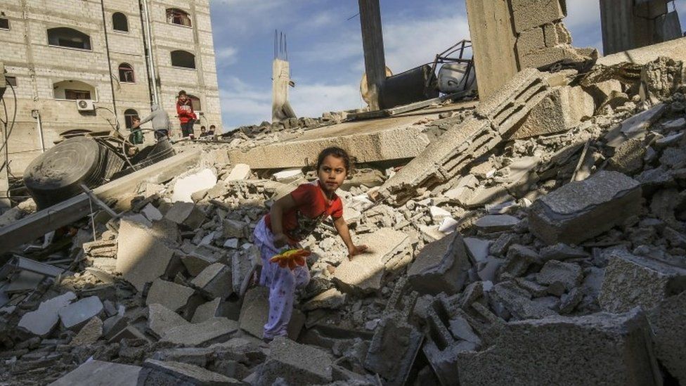 A Palestinian girl climbs on the remains of a building that was destroyed during an Israeli air strike on Rafah on 5 May 2019