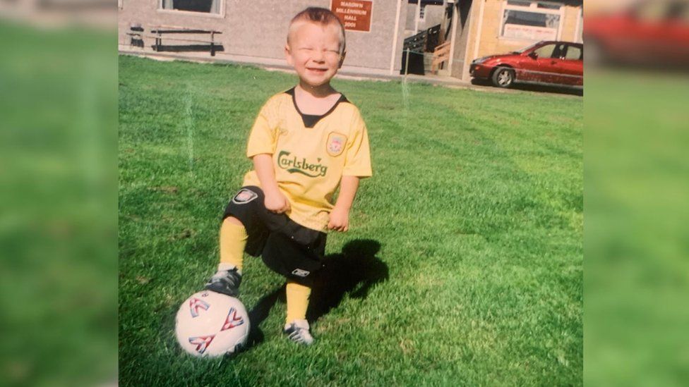 A young Lucas Martin with a football