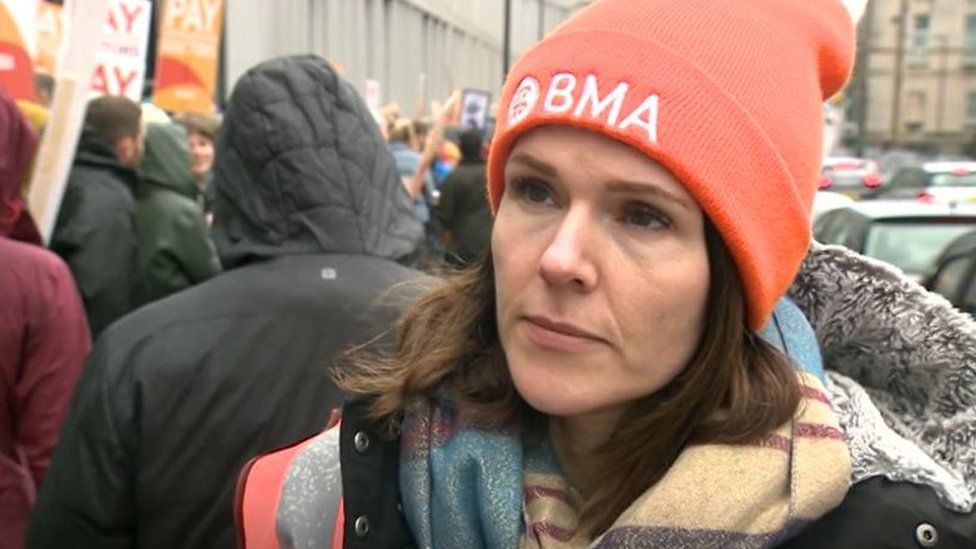 A female doctor in an orange hat at a picket line
