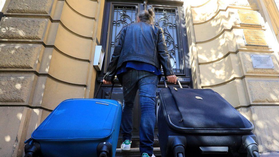 Person with suitcases on doorstep