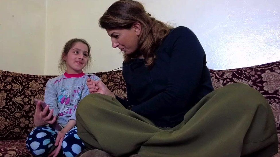 Raghad seated with BBC reporter Carine Torbey in her aunt's house