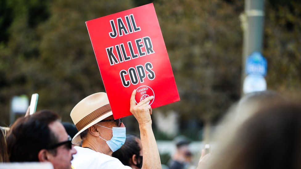 A protester at the BLM marches last summer holds a sign aloft which reads: Jail Killer Cops