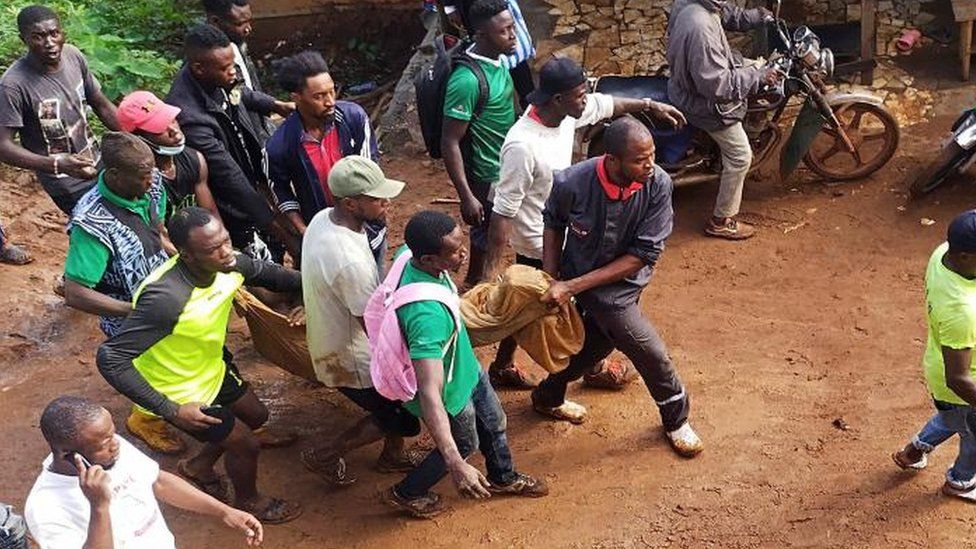 People carry a body found under the rubble after a dam collapsed caused flooding, destroying homes and killing dozens in Mbankolo, Yaounde, Cameroon October 9, 202