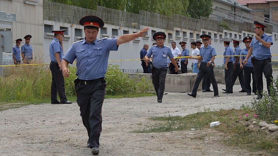 Kyrgyz police officers gather outside the Chinese embassy in Bishkek on August 30, 2016.