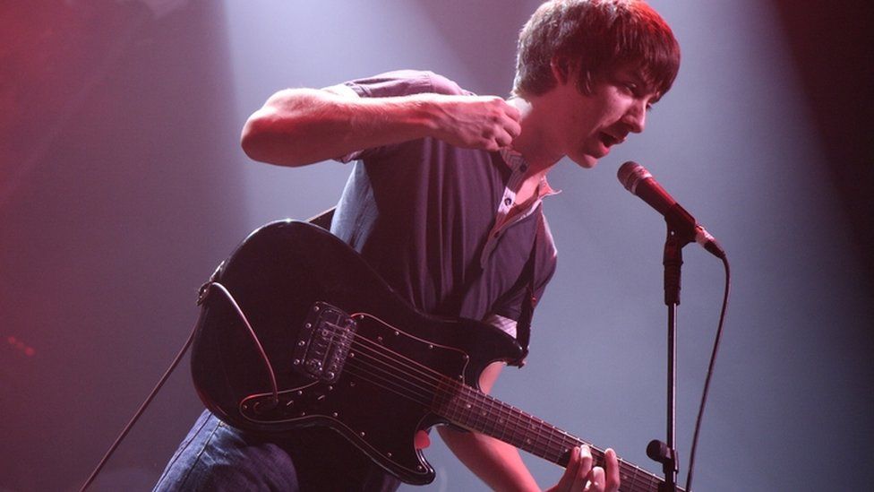 Alex Turner playing a black Fender Stratocaster in 2007