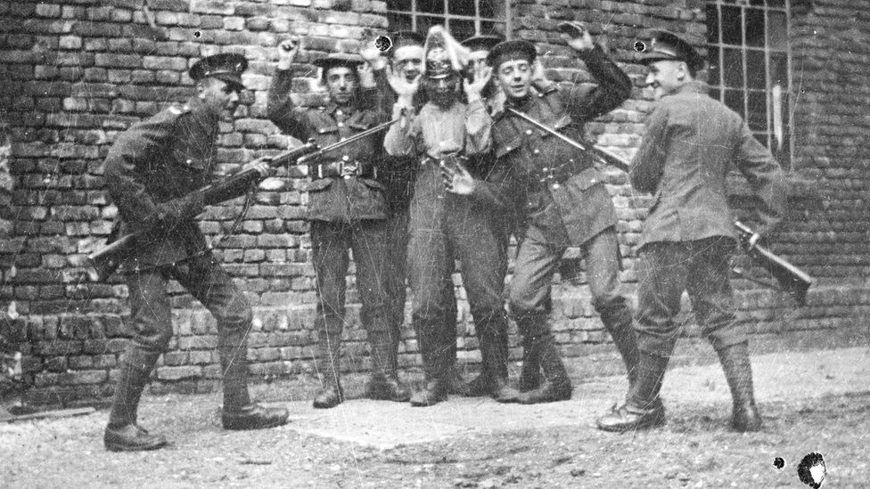 Soldiers dressed as the enemy pretending to get captured by colleagues in 1919