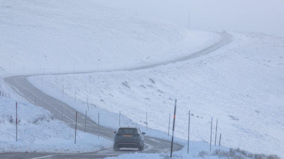 A car makes it way along the A939 after heavy snowfall in the Cairngorms, Scottish Highlands.