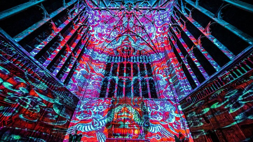 Red and blue prints glowing against the backdrop of the cathedral ceiling