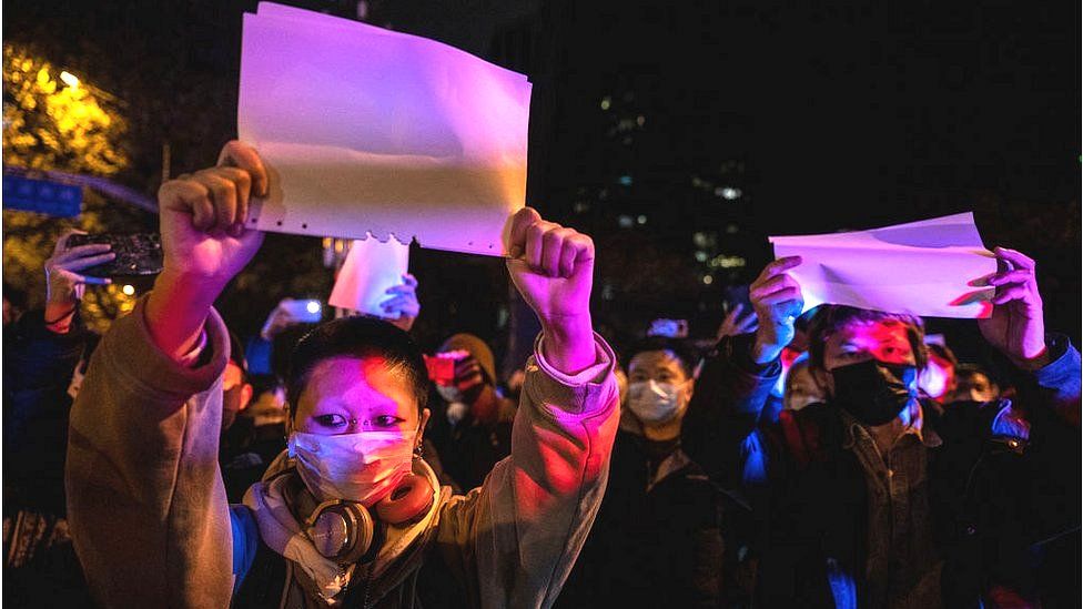 Протестующие держат белый лист бумаги против цензуры во время акции протеста против строгих нулевых мер Китая по COVID 27 ноября 2022 года в Пекине, Китай