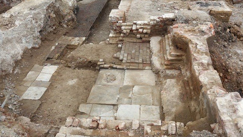 Image showing an excavated room with areas of brick and Yorkstone paving of different sizes and heights
