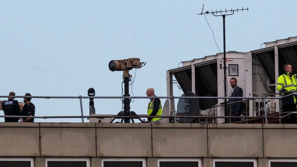 Police and officials on roof of Gatwick with anti-drone devices