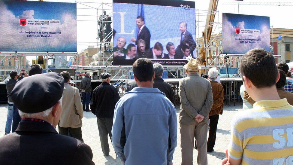 Albaneses viendo la televisión en la plaza central de Tirana