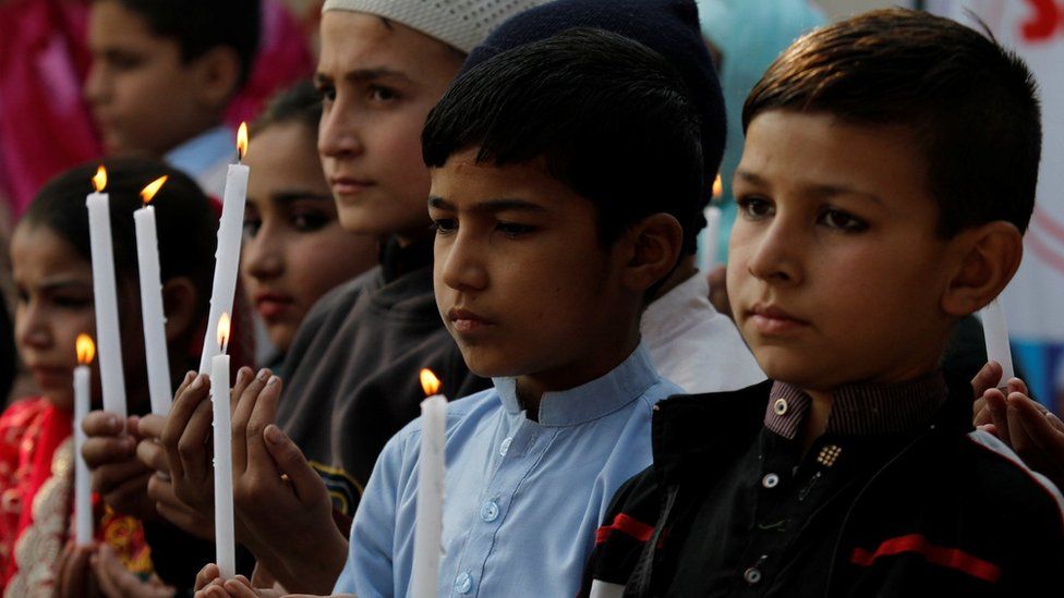Pakistani school children light candles and pray to mark the second anniversary of terrorists attack on Army Public School attack in Peshawar, Pakistan, 16 December 2016