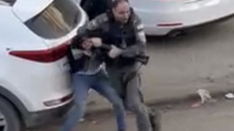 Still from video showing policeman and Ammar Mefleh struggle