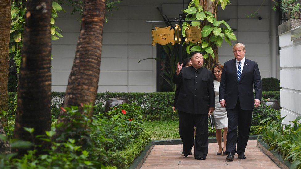 US President Donald Trump walks with North Korea's leader Kim Jong Un during a break in talks