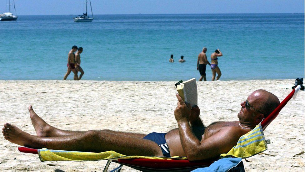 A male tourist reads a book in a hammock on Kata beach in Phuket, Thailand, 31 January 2005.