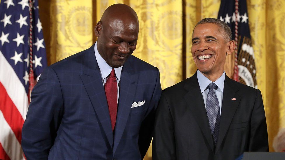 Barack Obama smiles up at National Basketball Association Hall of Fame member and legendary athlete Michael Jordan