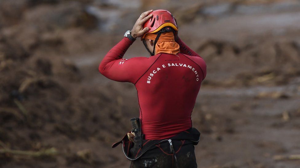 A rescuer holds his head in his hands