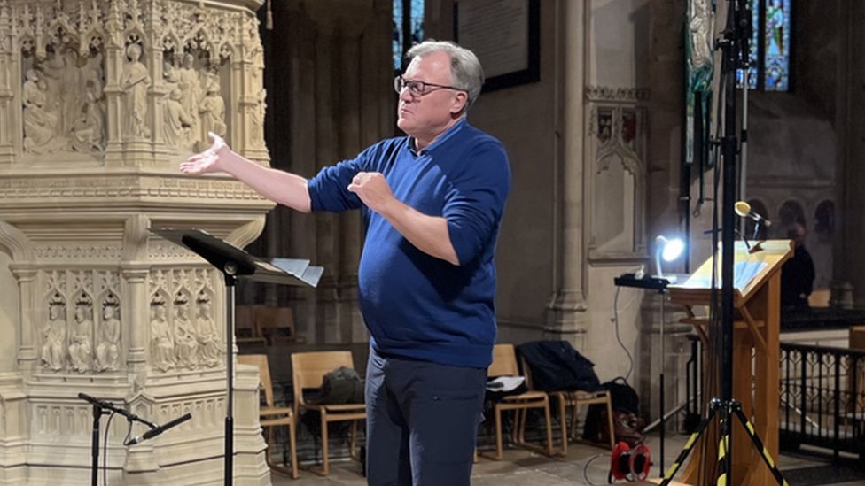 Former MP conducting in rehearsals in Norwich Cathedral