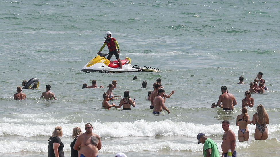 People enjoy the warm weather on Bournemouth beach. Met Office said Friday is the third hottest UK day on record as temperatures reached 37.8C at Heathrow Airport.