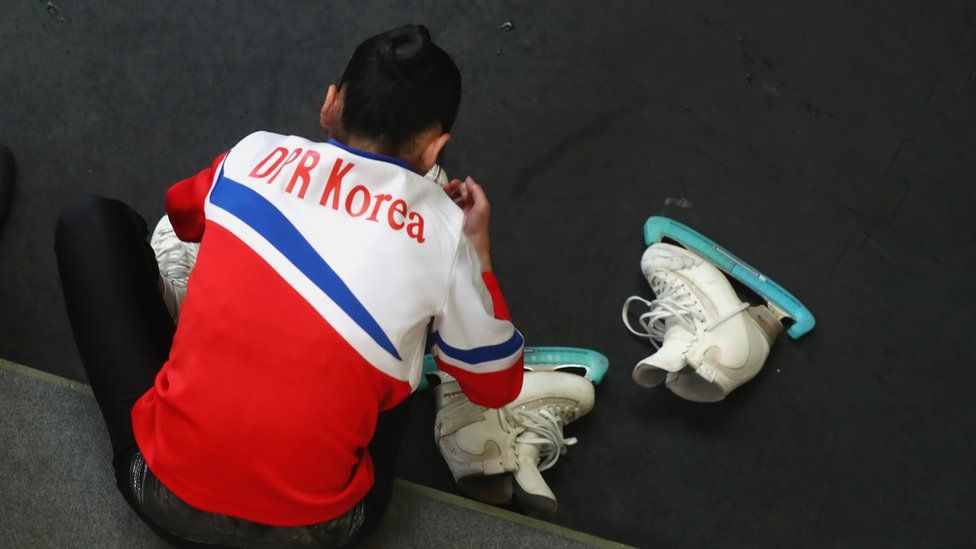 Tae Ok Ryom adjusts her skates prior to her Pairs short program with Ju Sik Kim