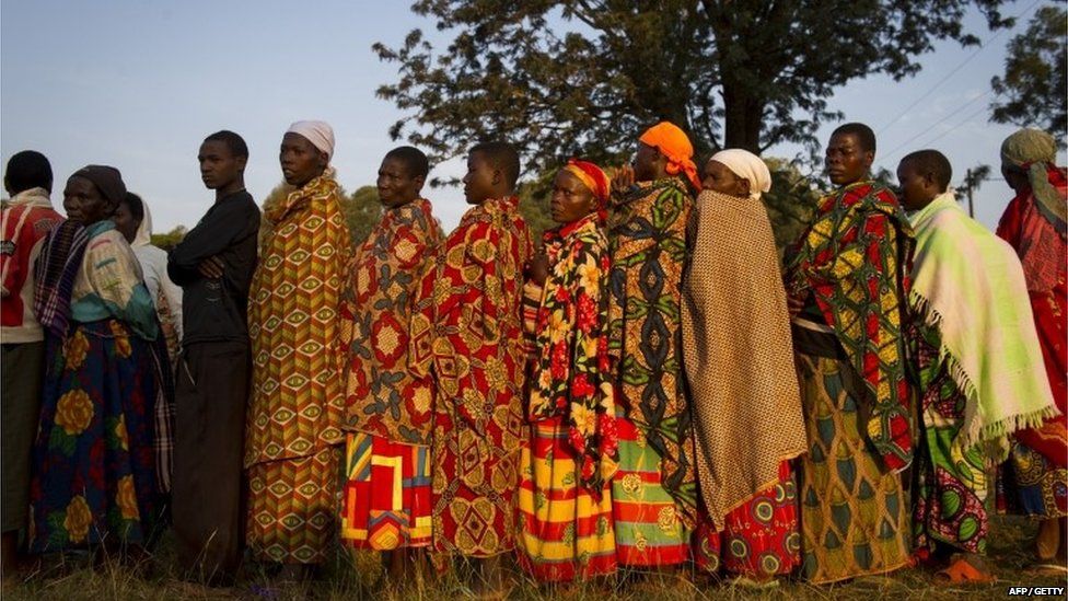 Residents line up prior to casting their vote in the village of Buye