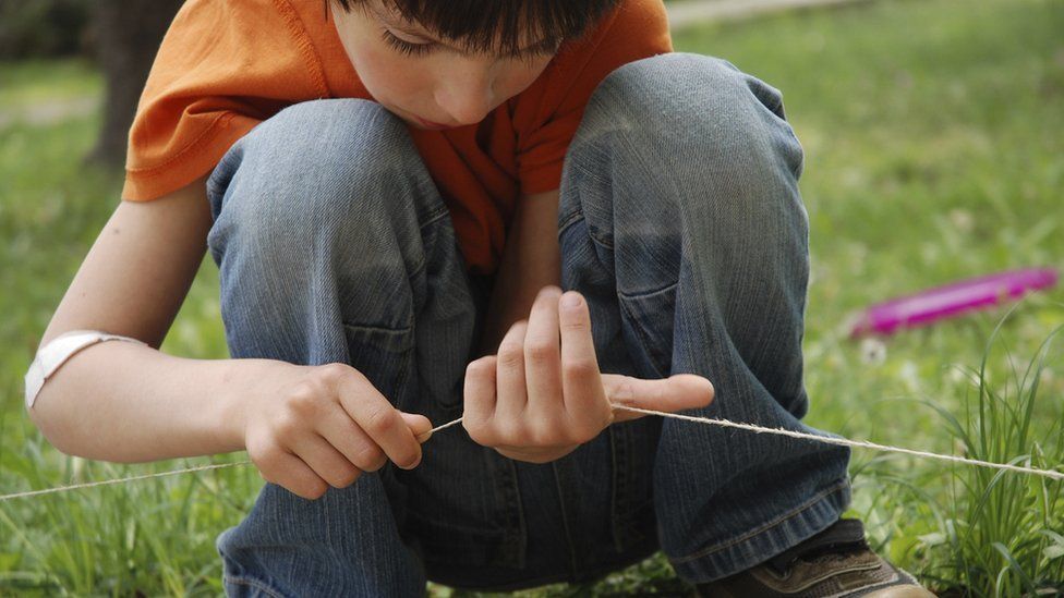 A boy playing with string