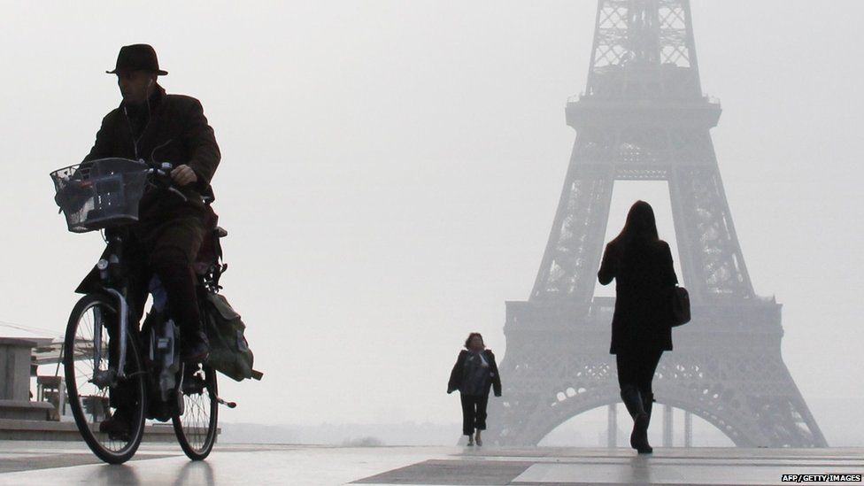A man rides a bicycle on the Esplanade du Trocadero in front of the Eiffel tower, on March 11, 2014