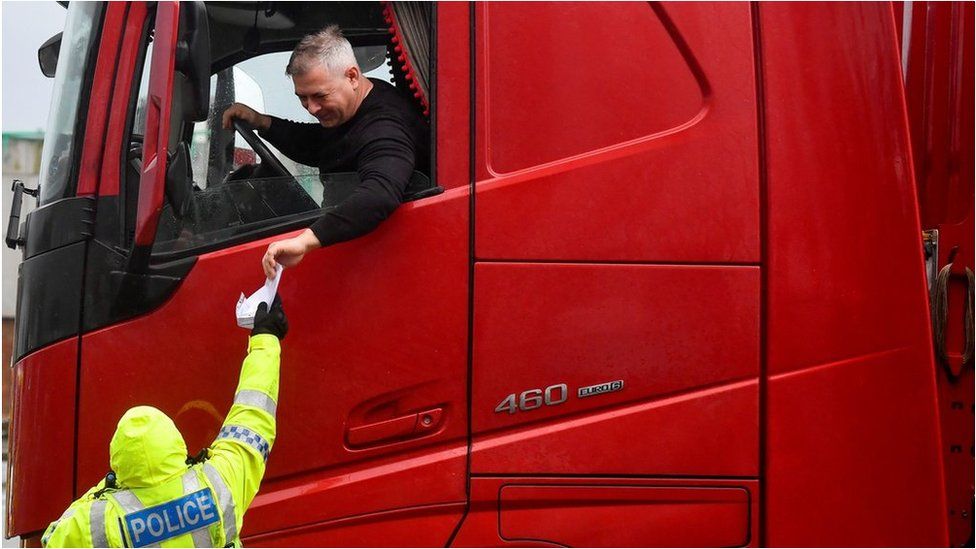 Полицейский проверяет документы водителя грузовика в Дувре