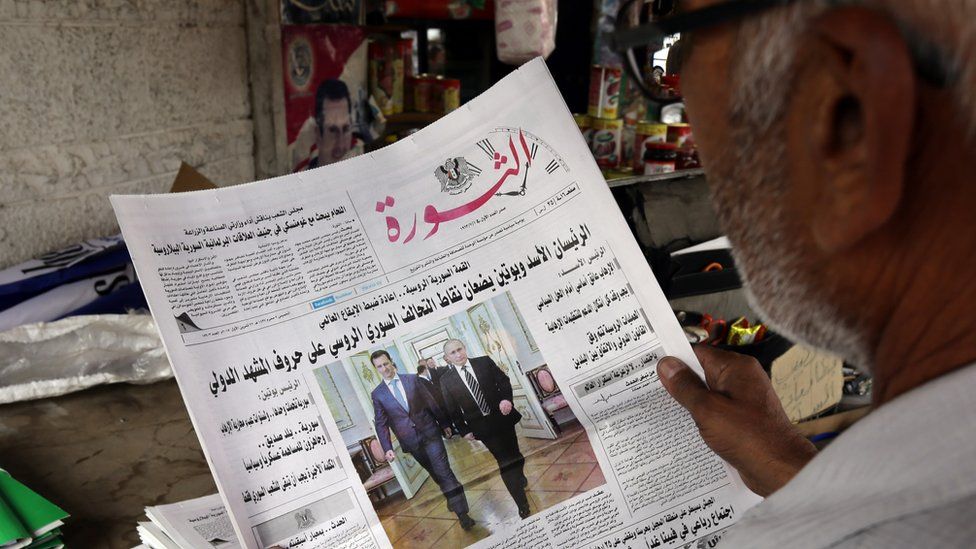 Man reading Syrian newspaper