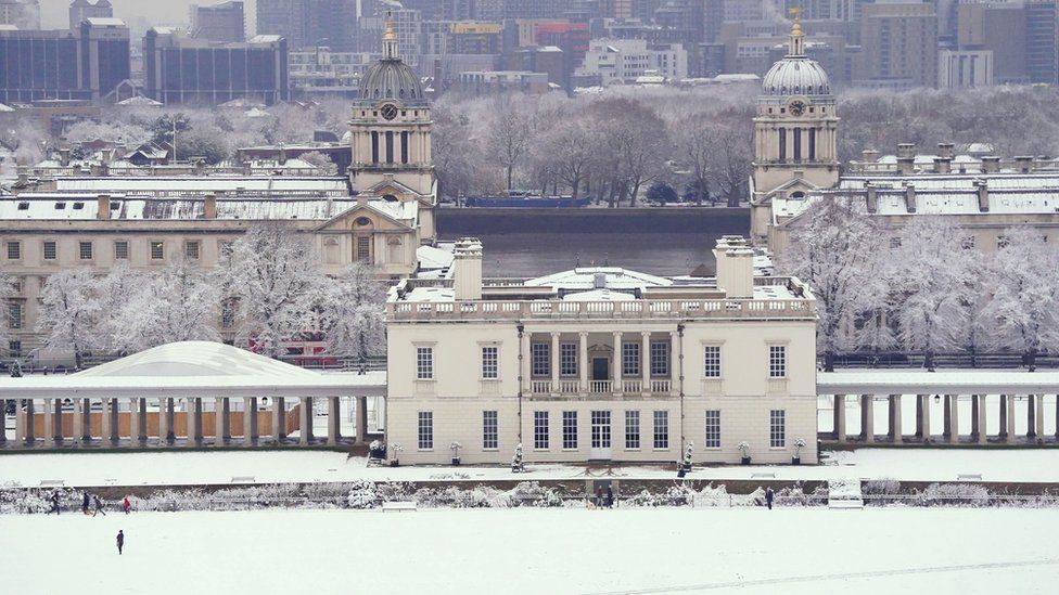 People walk through the snow in Greenwich Park