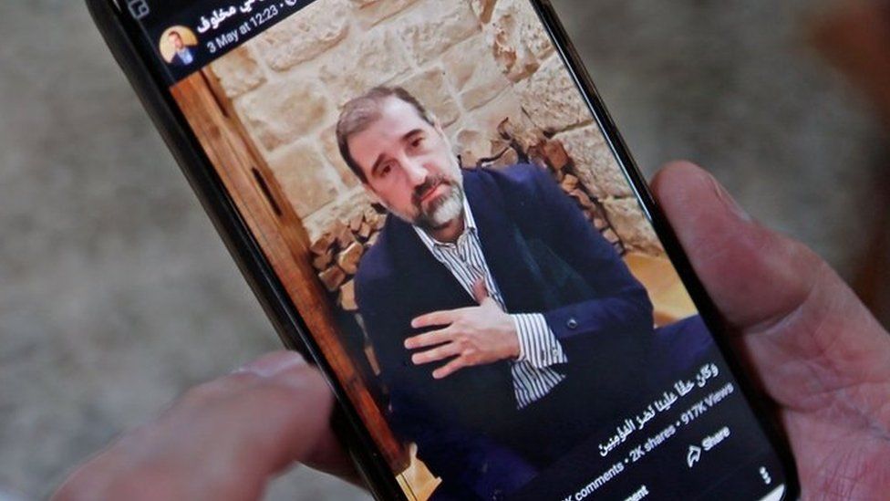 Picture of Rami Makhlouf on a mobile phone