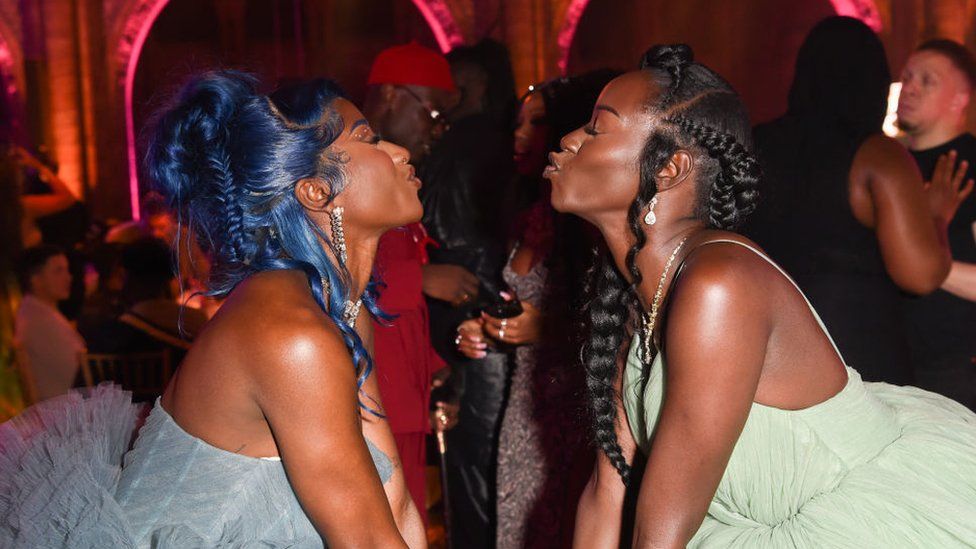 It's Just Nife and Priscilla Anyabu attend the GUAP Gala 2022 at the Natural History Museum on October 07, 2022 in London. They are seen in profile, air-kissing about a foot apart. They both have elaborate hairstyles.