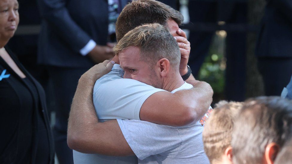 Mourners hug as they participate in a ceremony marking the 20th anniversary of the 9/11 attacks at the World Trade Center site in New York City, September 11, 2021