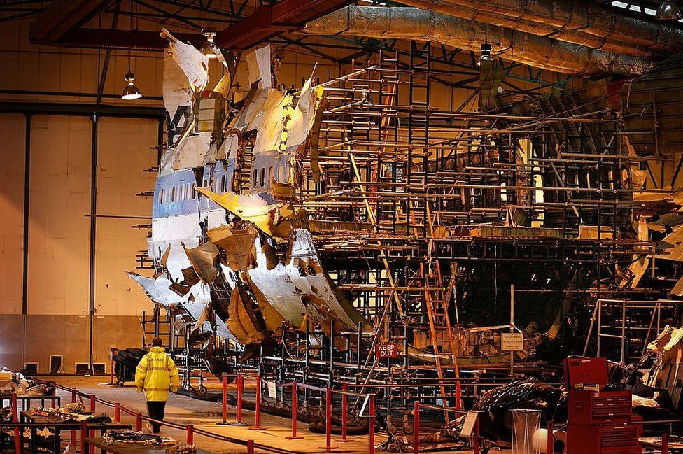 A large scaffold with parts of a plane's fuselage assembled around it