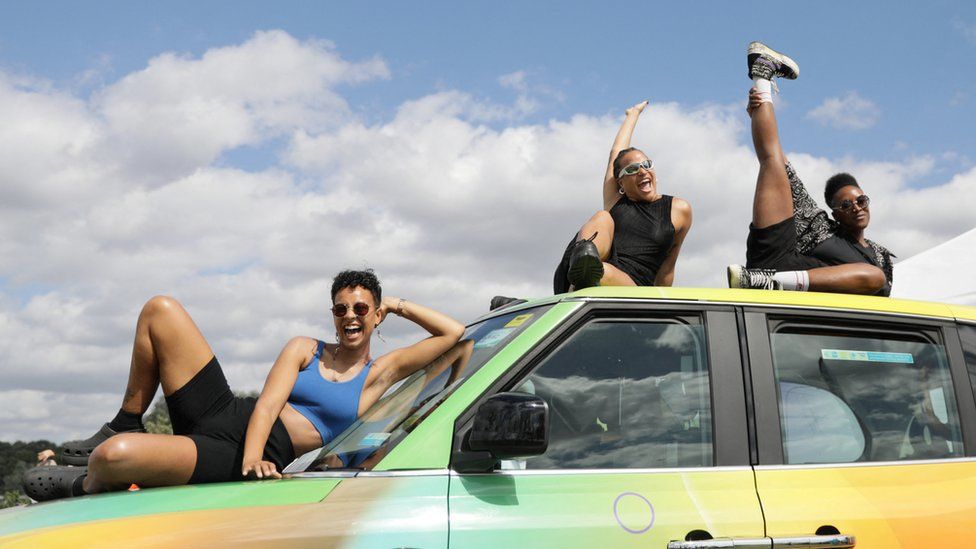 People pose on top of a car at UK Black Pride