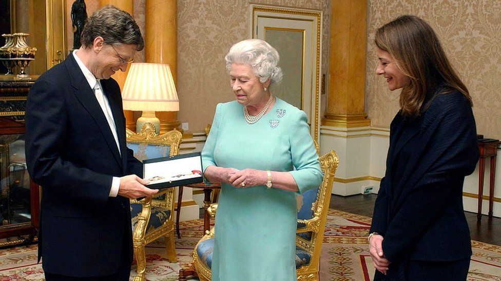 Queen Elizabeth II presents Bill Gates with his honorary knighthood at Buckingham Palace, alongside his wife Melinda, in London 2015